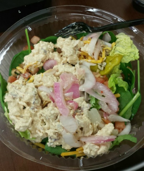chipotle chicken salad on greens with pickled onions
